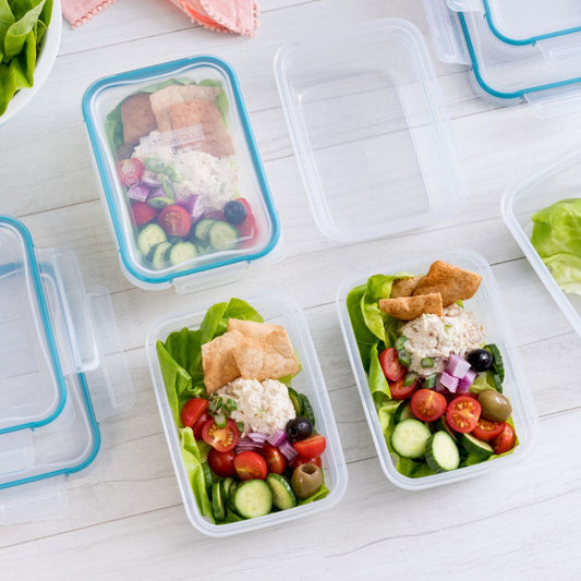 Prepared salads in containers on a white surface