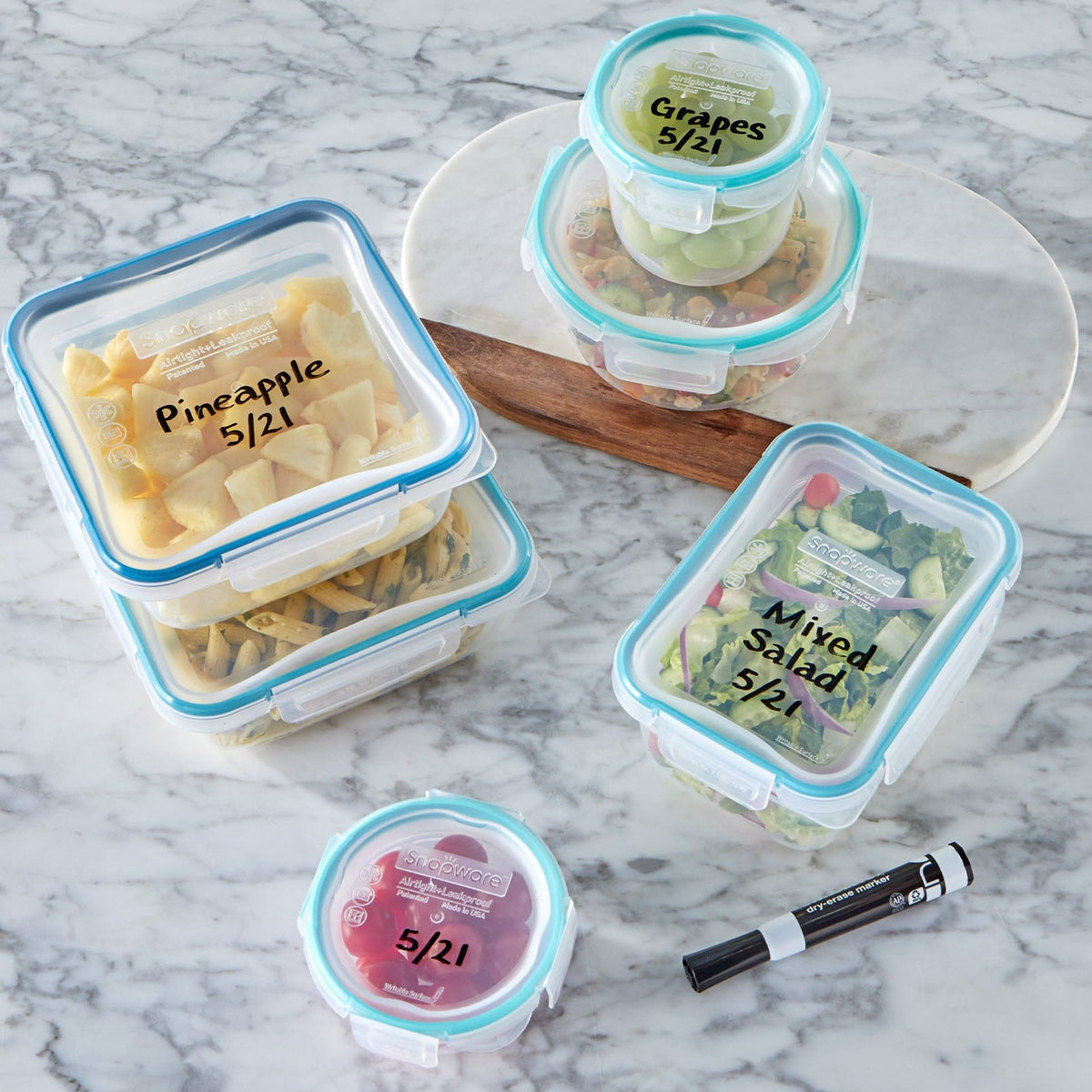 Containers with labeled lids on a marble surface, featuring text about writeable and erasable lids.