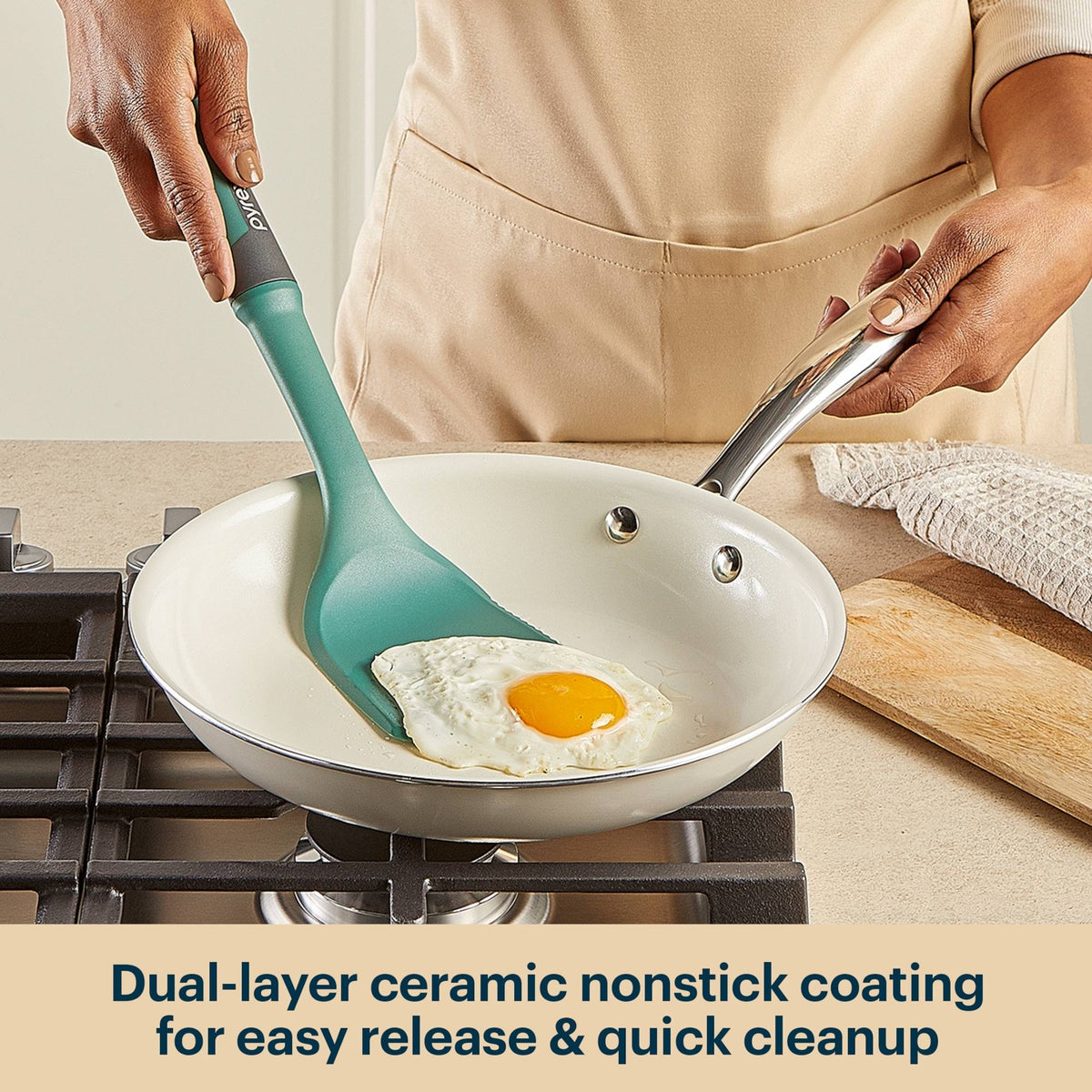 Person cooking an egg in a frying pan with a green spatula, kitchen setting.