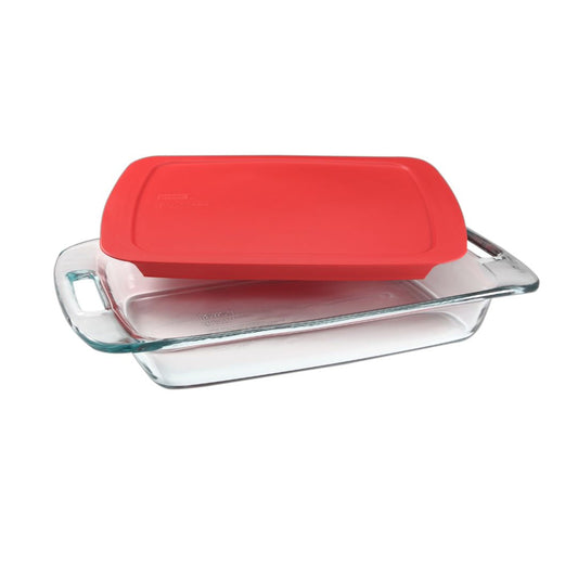 Glass baking dish with a red lid on a white background