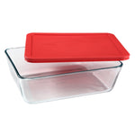 Clear glass food storage container with a red lid on a white background